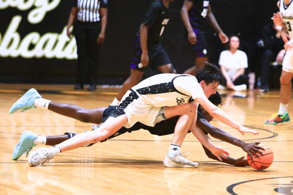 Gainesville's Craig Thomas Jr. (4) pokes the ball away from Buchholz's Jacob Bromirski (0). Photo by C.J. Gish