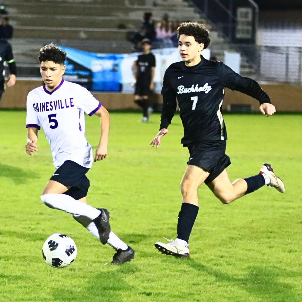 Gainesville's Jeffery Ortega (5) dribbles the ball downfield ahead of Buchholz's Paulo Amador (7). Photo by C.J. Gish