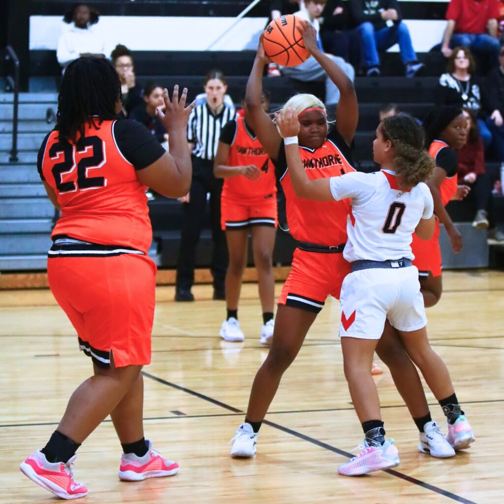 Hawthorne's Ariana Wilson (1) keeps the ball away from The Rock's Bianca Scott (0). Photo by C.J. Gish