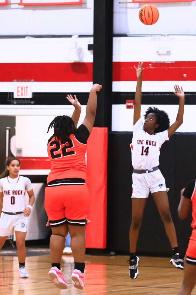 Hawthorne's Brooklynn Gillins (22) puts up a shot against The Rock's Darielle Grant (14). Photo by C.J. Gish