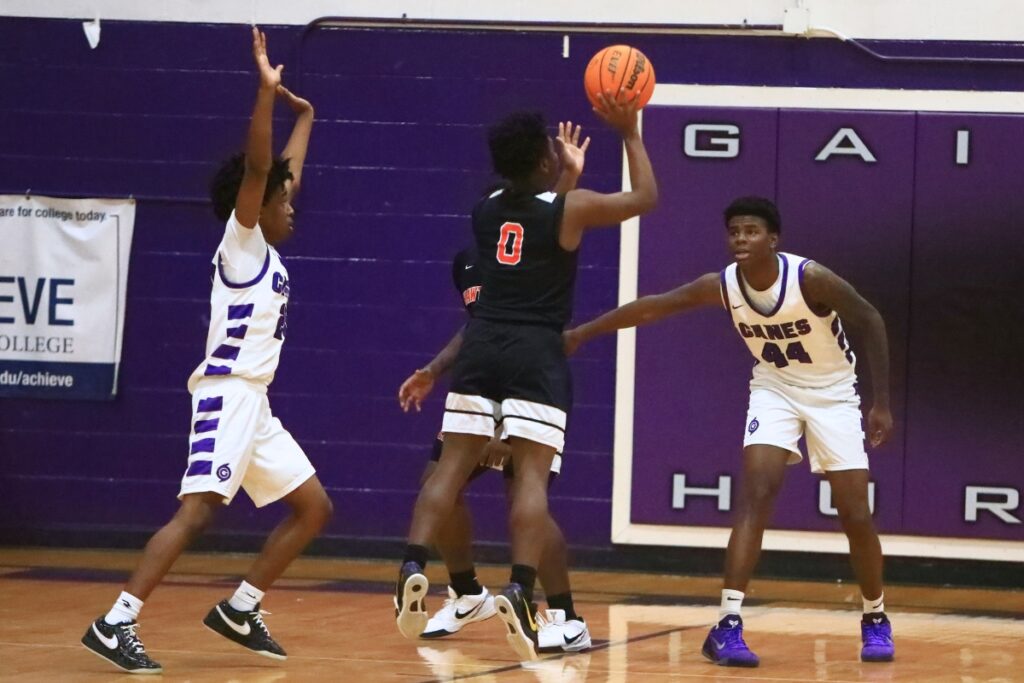 Hawthorne's Darian Bowie (0) puts up a shot between Gainesville's Anthony Jenkins Jr. (20) and AJ Hall (44). Photo by C.J. Gish