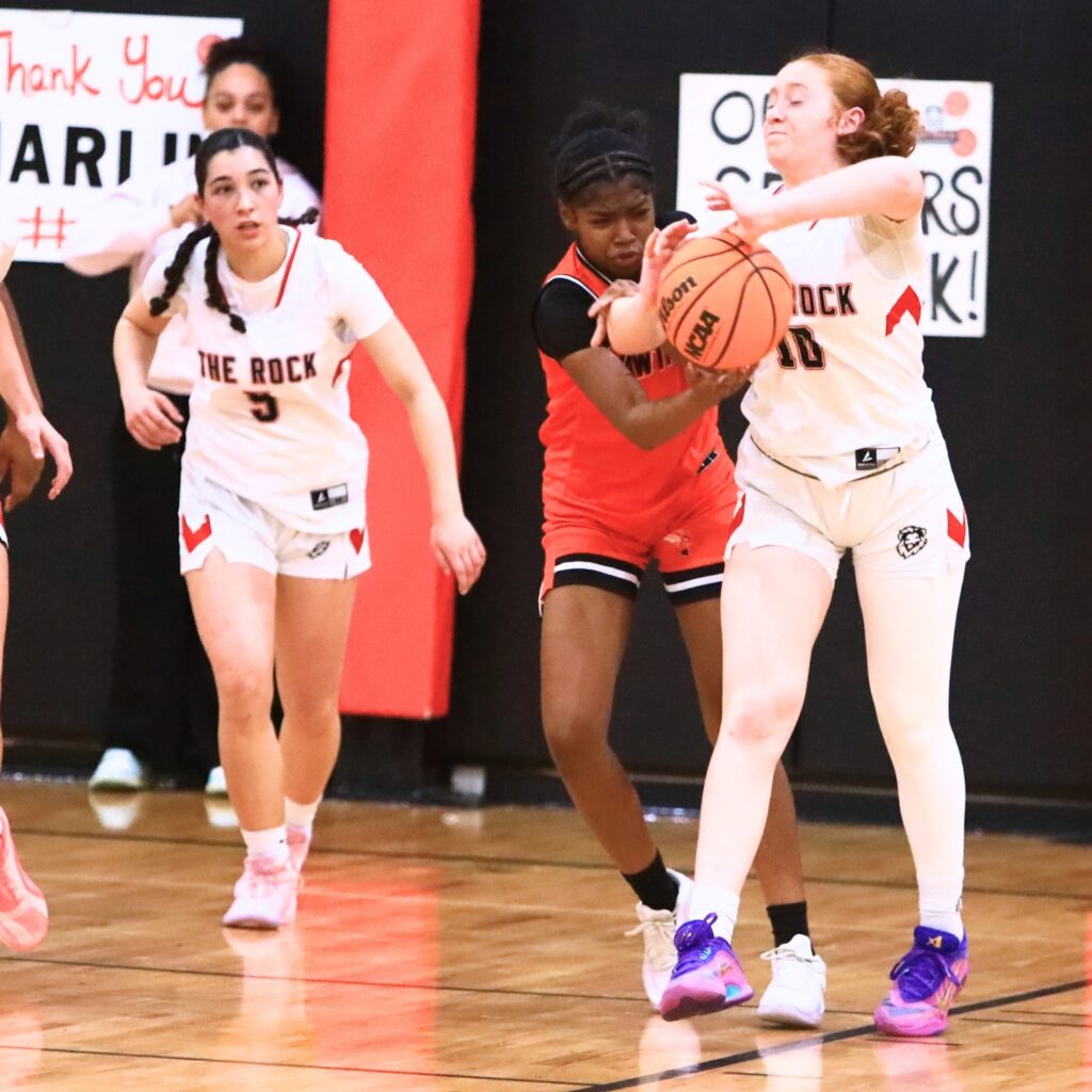 Hawthorne's Raylen Cue (4) and The Rock's Ruby Patterson (10) battle for the ball. Photo by C.J. Gish