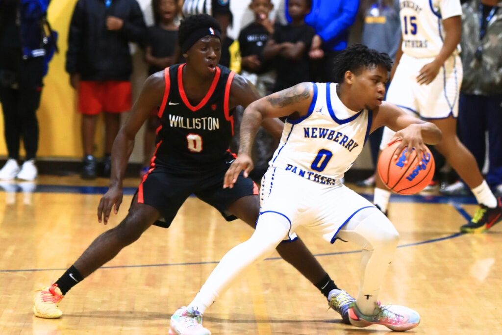 Newberry's Craig Middleton (0) dribbles the ball against Williston's Jac Edwards (0). Photo by C.J. Gish 1 (1)