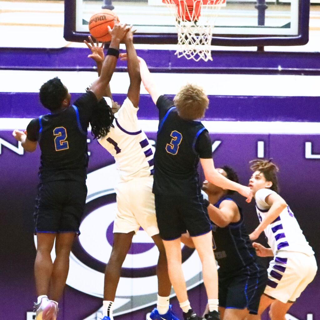 Newberry's Henry Mathias (3) and Kaleb Wood (2) battle for a lose ball with Gainesville's Willie Brooks (1). Photo by C.J. Gish