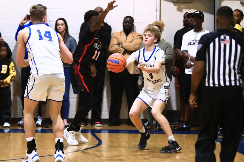 Newberry's Henry Mathias (3) passes the ball to Colton Sembower (14) against Williston. Photo by C.J. Gish