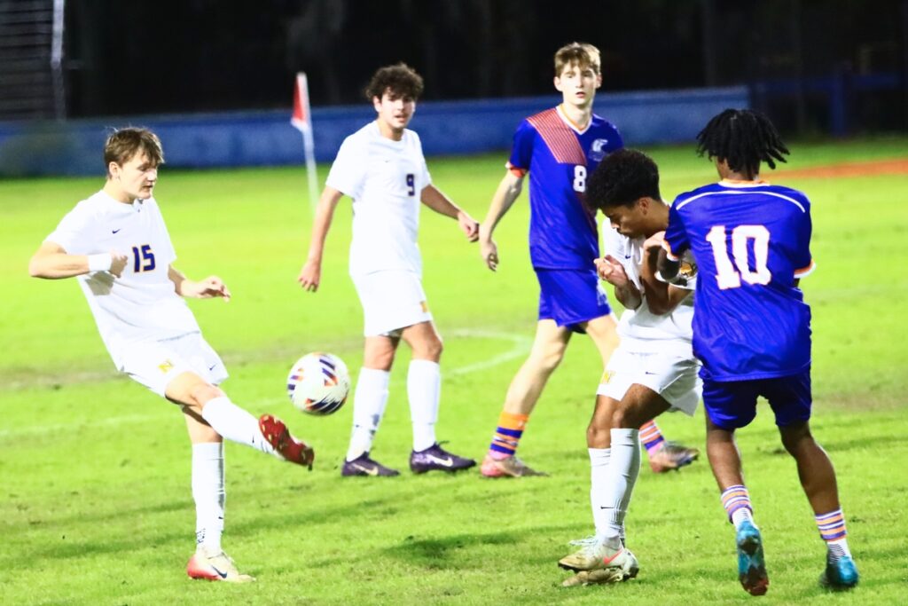 Newberry's Joseph Clark (15) kicks the ball against P.K. Yonge. Photo by C.J. Gish