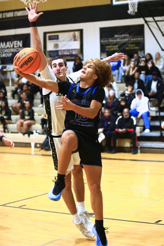 Newberry's Kai Washington (13) puts up a shot against Buchholz's Gabe Williams (21). Photo by C.J. Gish