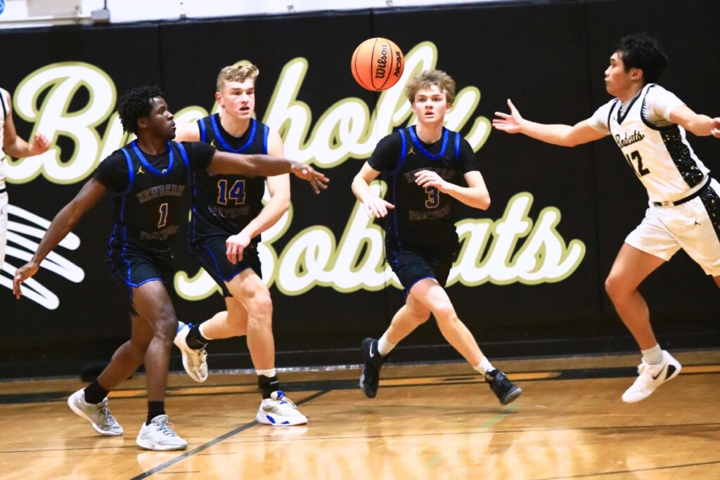 Newberry's Quantez Robinson (1), Colton Sembower (14) and Henry Mathias (3) go after a loose ball against Buchholz's Ezra Olmedo (12). Photo by C.J. Gish