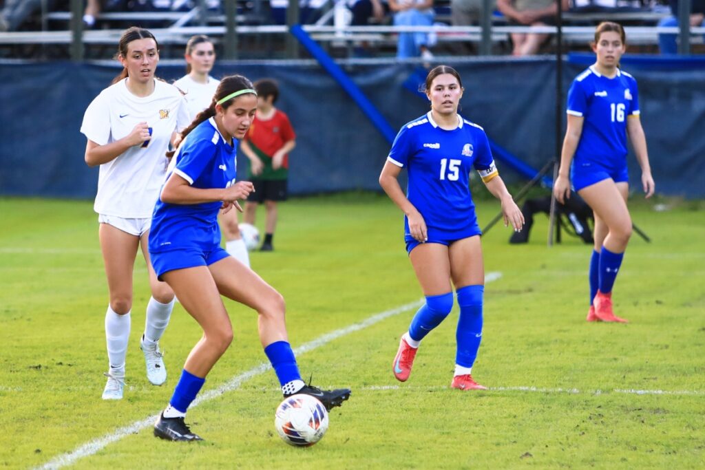 P.K. Yonge's Bella Young (20) dribbles the ball down the field against Newberry. Photo by C.J. Gish