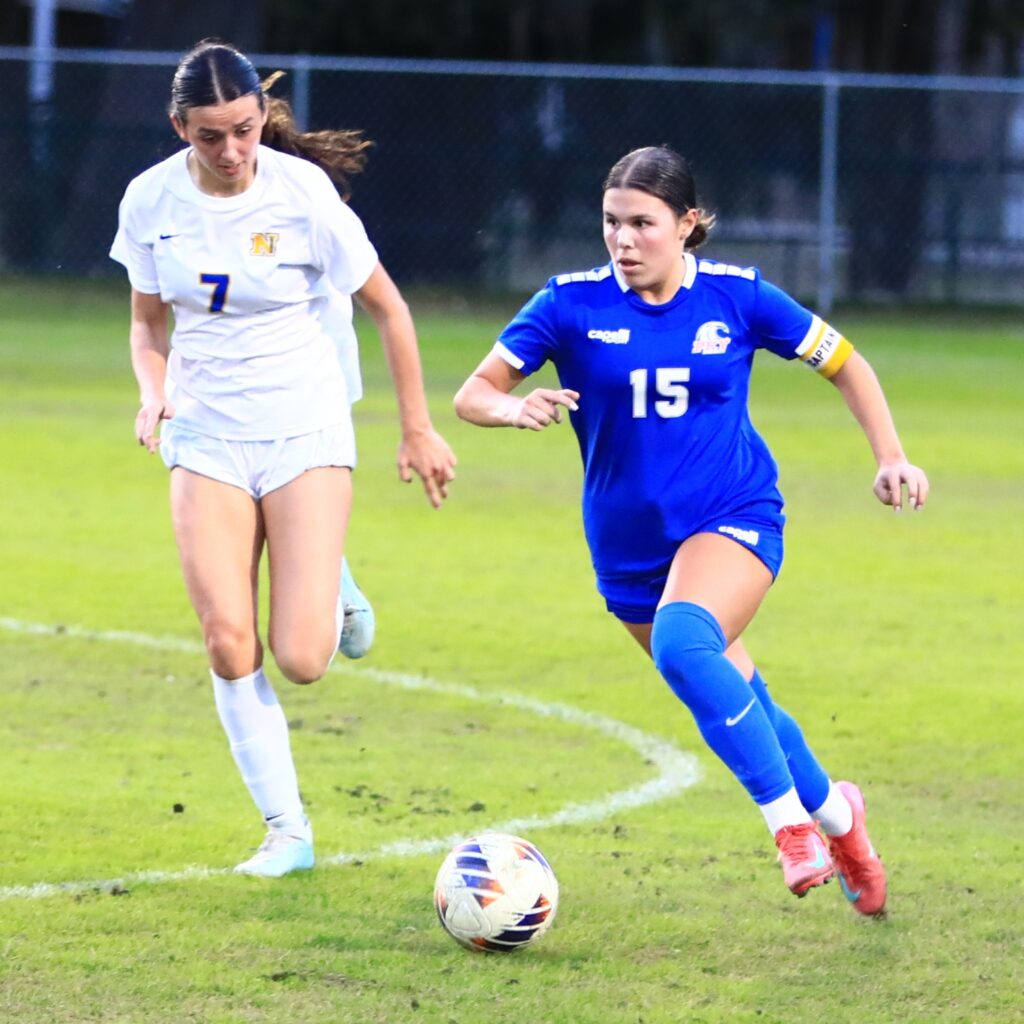 P.K. Yonge's Ellie Cervantes (15) gets past Newberry's Baylee Akers (7). Photo by C.J. Gish
