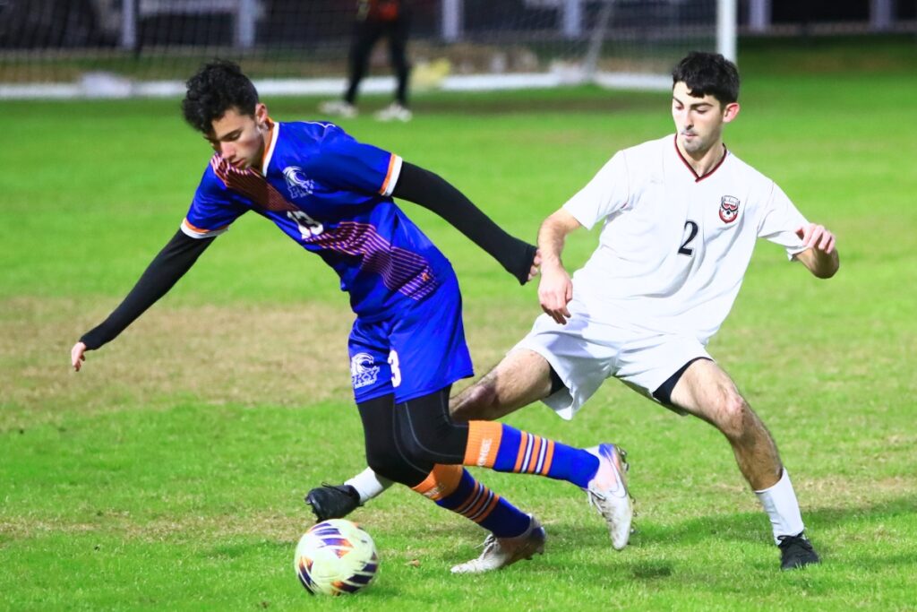P.K. Yonge's Fisher Cooper (13) and Williston's Braiden Muthard (2) battle for the ball. Photo by C.J. Gish