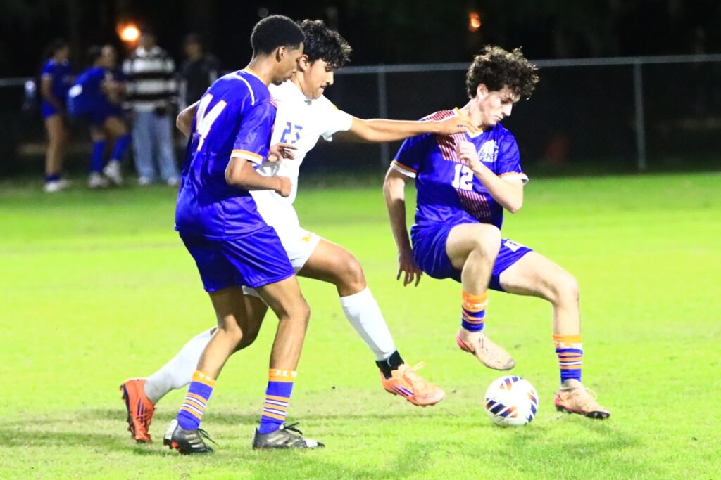 P.K. Yonge's Rowan Foley (12) and Manu Ozuzu-Bertrand (14) go after the ball against Newberry's Carlos Hernandez Ramos (23). Photo by C.J. Gish