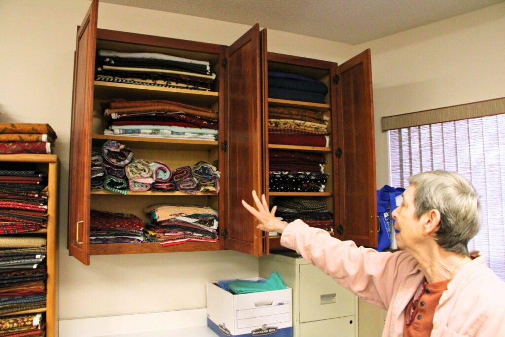 Quilter Sue Dubinsky looks through cabinets of fabric donated to The Knotty Ladies at Gainesville's Gethsemane Lutheran Church. Photo by Lillian Hamman