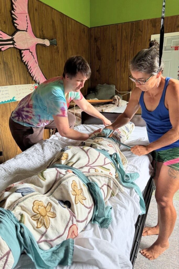 Rebecca Fletcher (left), the granddaughter of Carolyn Kinnard Ziffer, wraps her grandmother’s body with the help of family friend, Rebecca Wood. Photo by Abi Fletcher