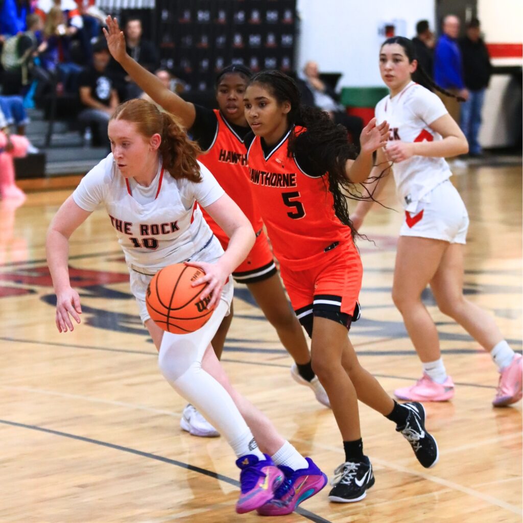 The Rock's Ruby Patterson (10) drives past Hawthorne's Miley Donald (5). Photo by C.J. Gish