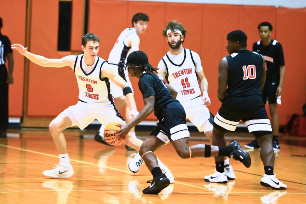 Trenton's Mason VunCannon (5) defends Hawthorne's Nathan Jennings (2). Photo by C.J. Gish