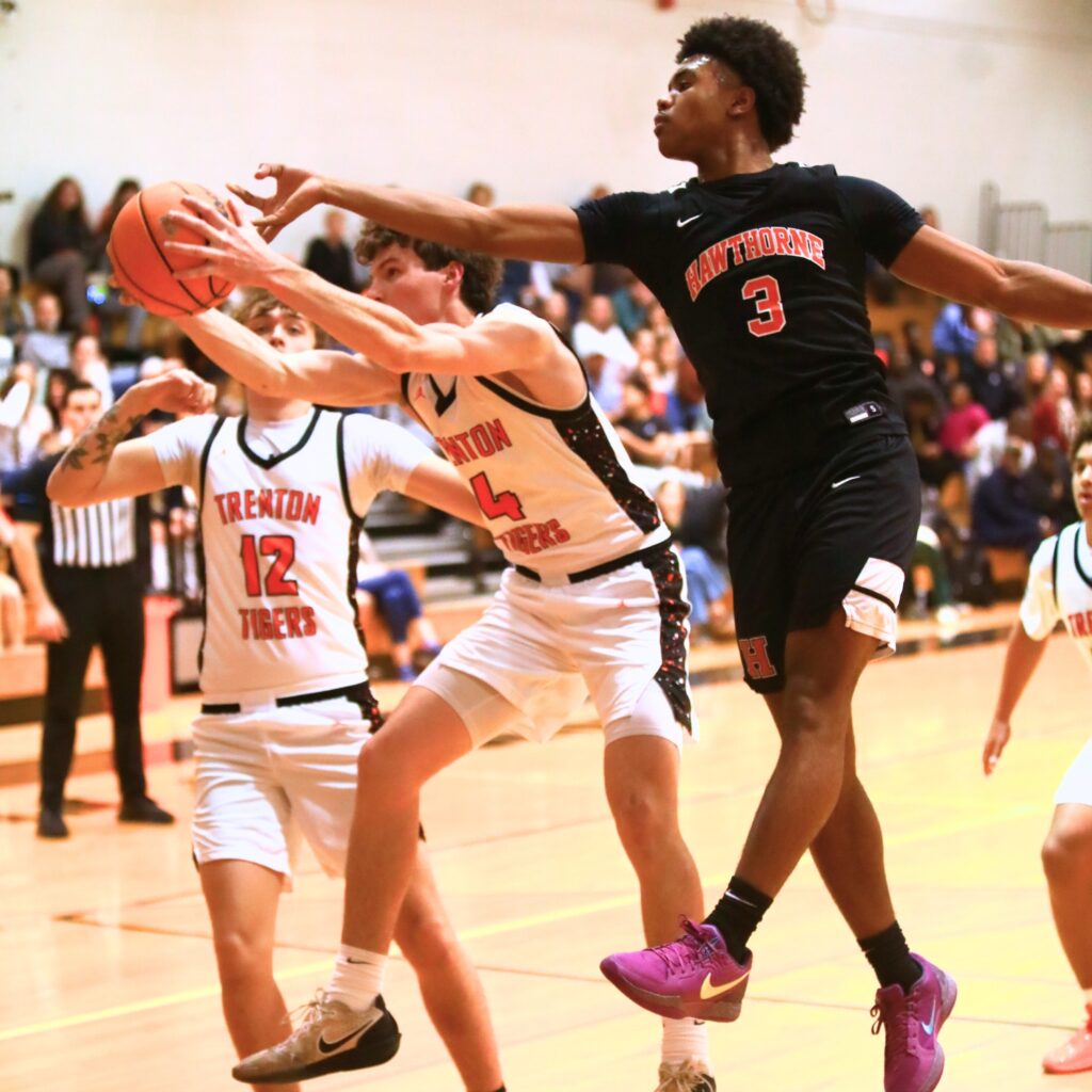 Trenton's Noah Owens (4) snags a rebound against Hawthorne's Dominick Harvey (3). Photo by C.J. Gish