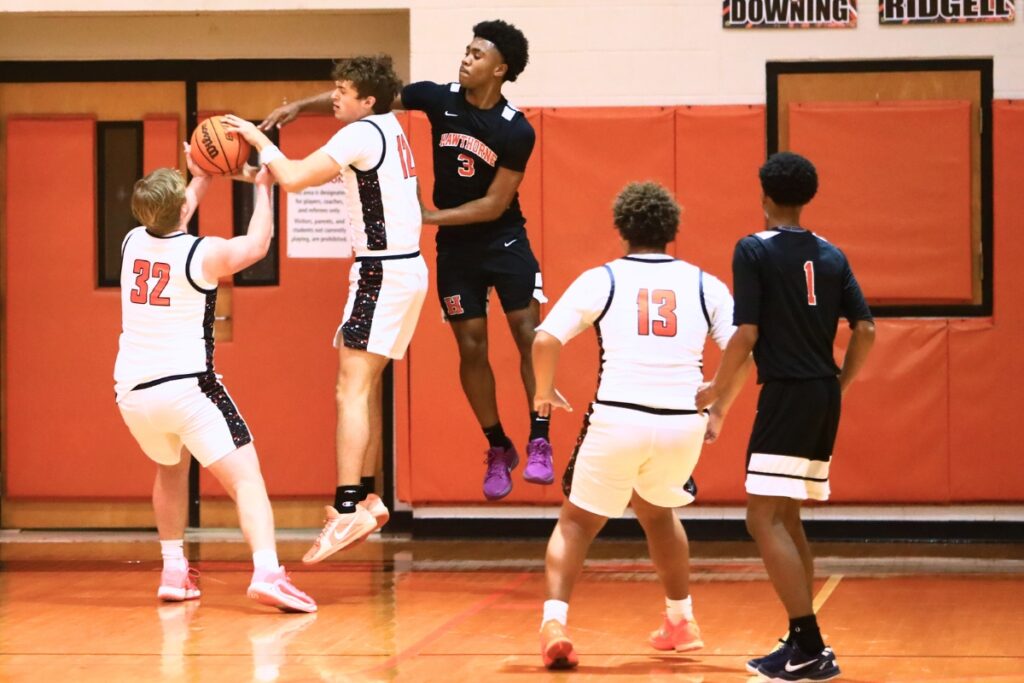 Trenton's Zaiden Bon (32) and Hunter Hilliard (12) go after a rebound in front of Hawthorne's Dominick Harvey (3). Photo by C.J. Gish