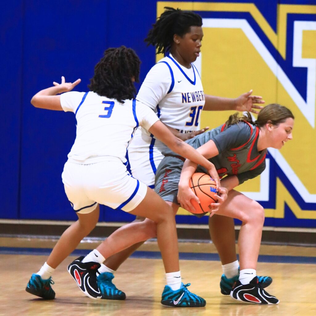 Williston's Baylee Cribbs (12) and Newberry's Rihanna Chiever (3) battle for the ball. Photo by C.J. Gish