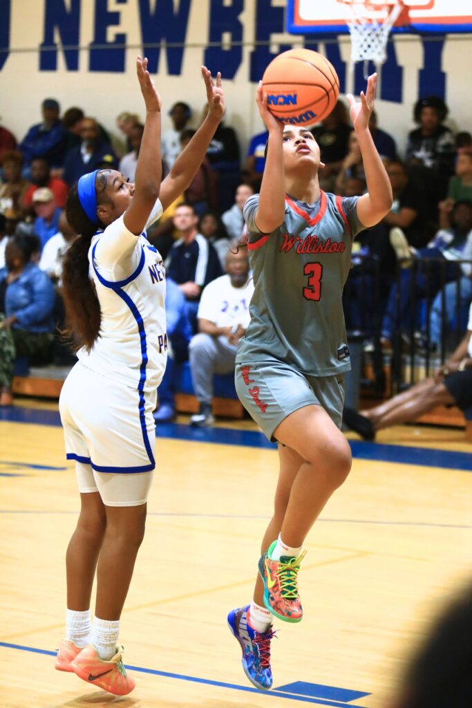 Williston's Delecia Dallas (3) goes up for a layup against Newberry's Brandy Whitfield (1). Photo by C.J. Gish