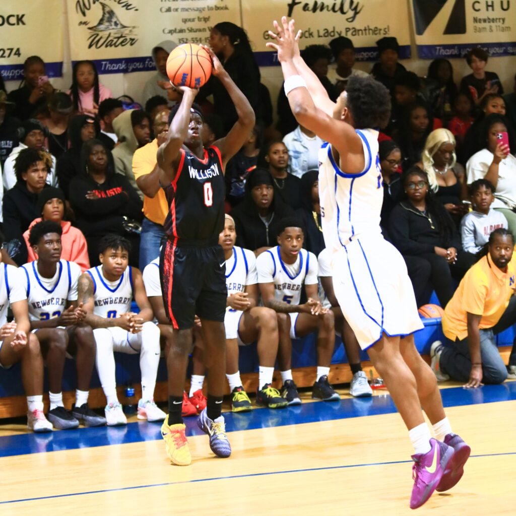 Williston's Jac Edwards (0) launches a 3-point shot against Newberry's Darius Debose (10). Photo by C.J. Gish