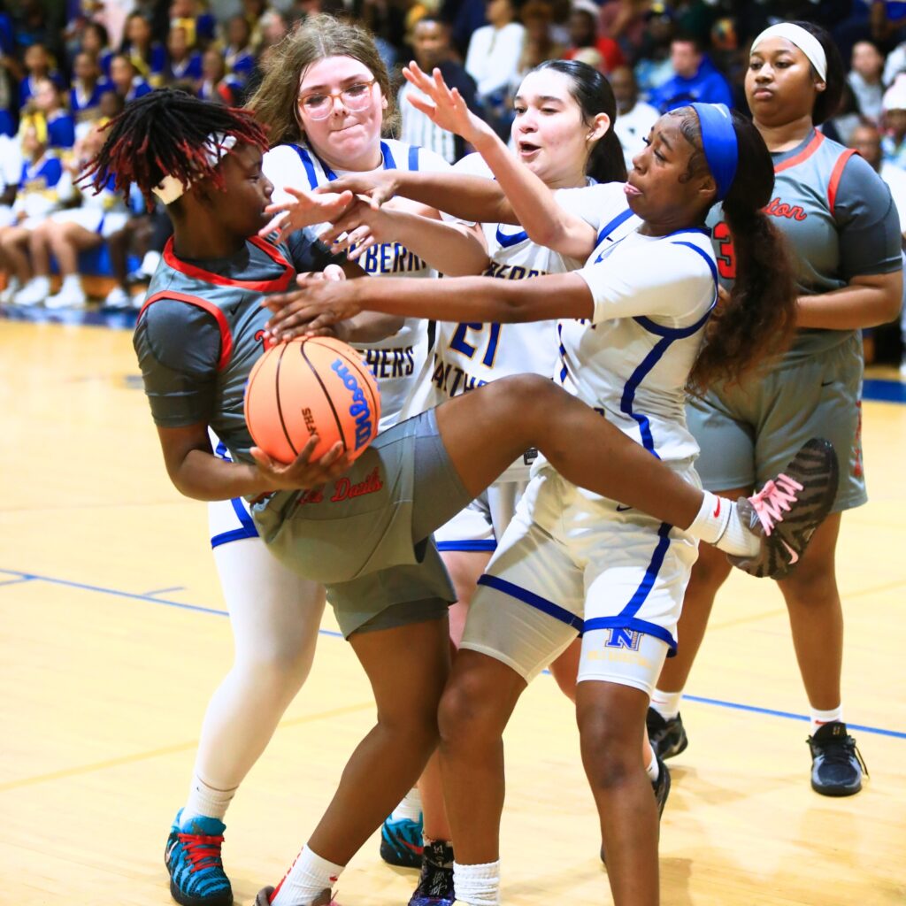 Williston's Janiyah Span (14) tries to keep the ball away from Newberry defenders. Photo by C.J. Gish