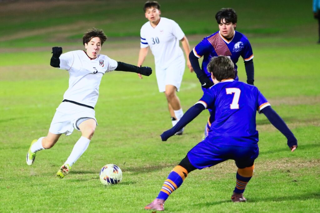 Williston's Noah Murphy (5) sets up for a kick between P.K. Yonge's Justin Kovar (2) and Blake Firsching (7). Photo by C.J. Gish 1 (1)