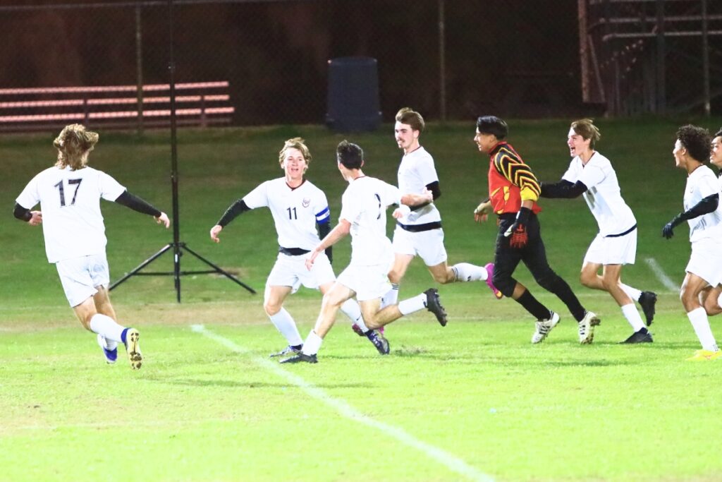Williston's Trace Green (11) celebrates with teammates after trying the score 1-1 against P.K. Yonge. Photo by C.J. Gish