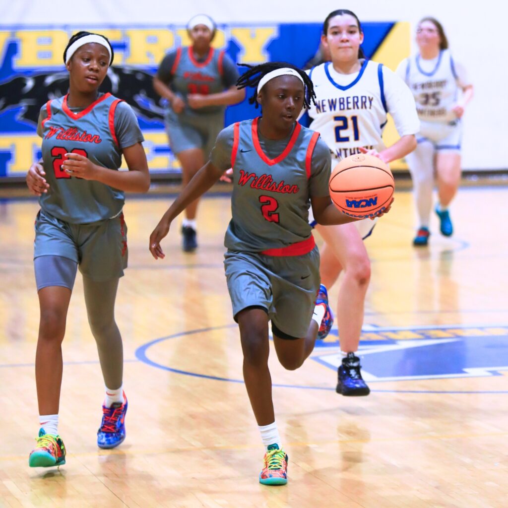 Williston's Trinity Solomon (2) brings the ball down the court against Newberry. Photo by C.J. Gish