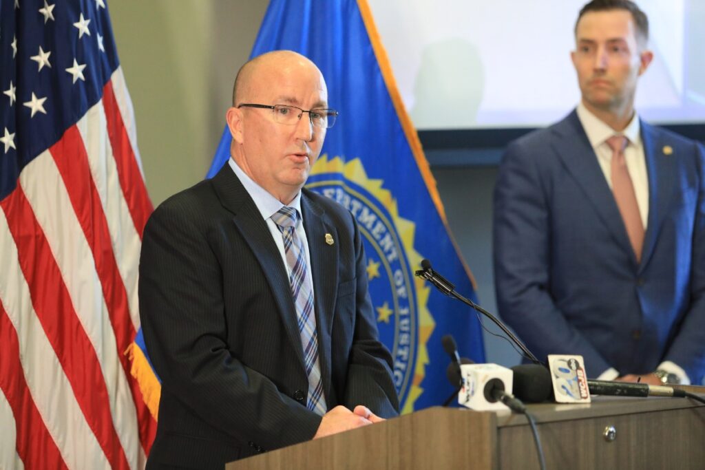 IRS-Criminal Investigations Florida Field Office Special Agent in Charge Ronald Loecker speaks from a podium at the press conference.
