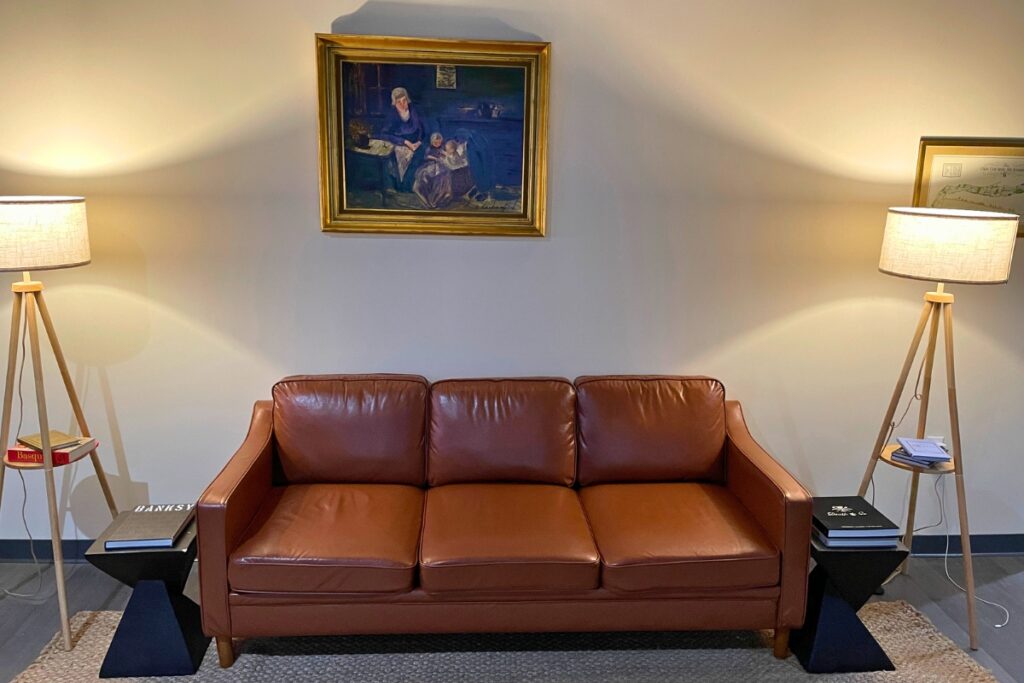 A leather couch with a painting above in a golf bay at Future Country Club.