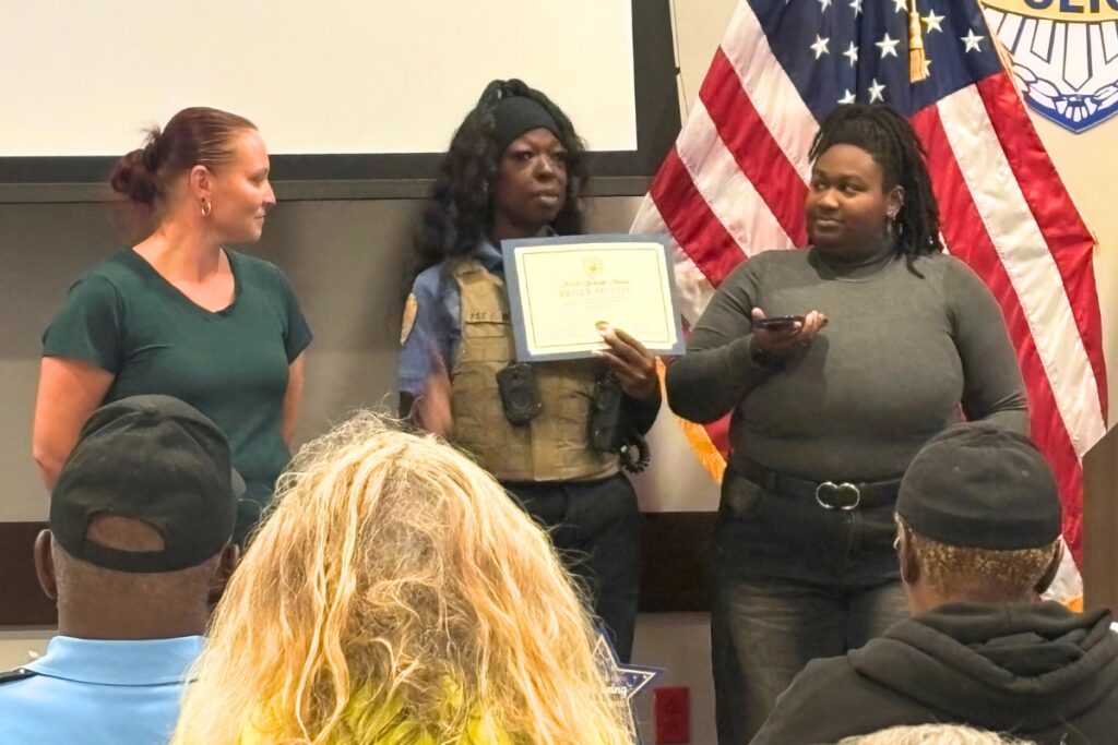 GPD School Crossing Guard Coordinator Pamela Miles, center, and parent Lauren Dreama, left, present Renee McCoy's School Crossing Guard of the Year award. Renee's daughter, Jay, at right, accepts in her absence.