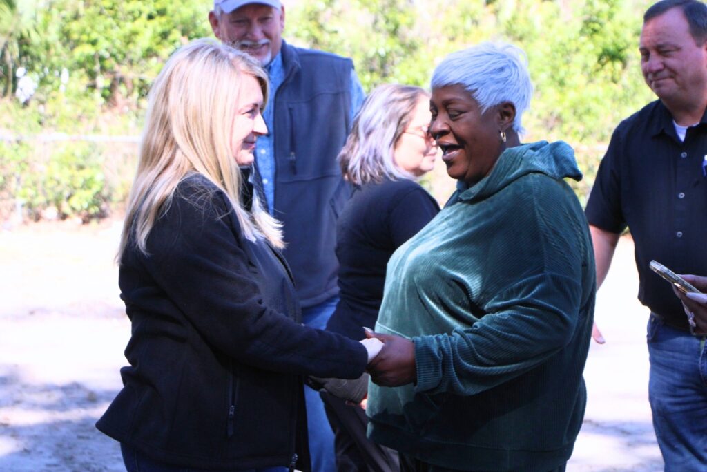 Levy County Commissioner Desiree Mills (left) congratulates Tlama White on her new home. Photo by Lillian Hamman
