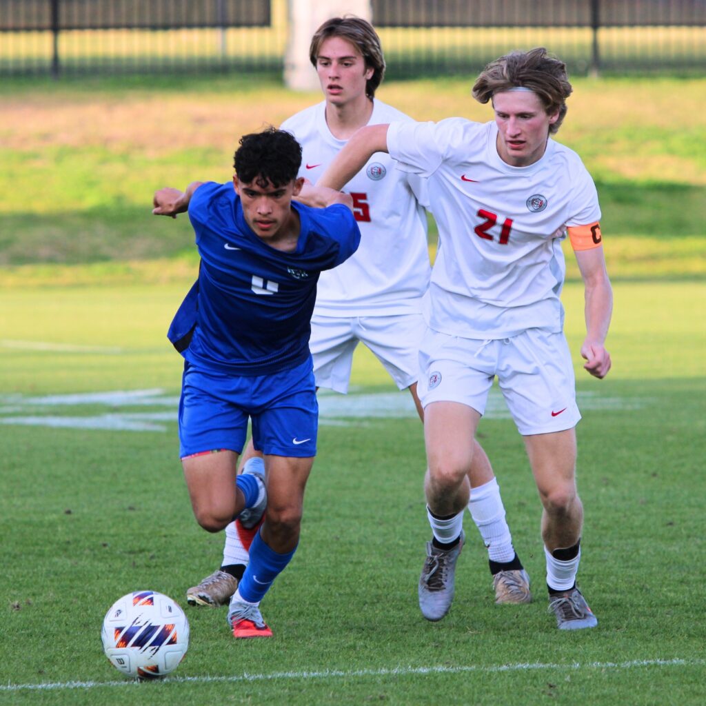 Santa Fes Mason Kramer (21) jousts with a Somerset Academy player during sprint for the ball against Somerset Academy-Canyons (Boynton Beach) in the Class 3A state semifinals. Photo by Vinnie Cammarano