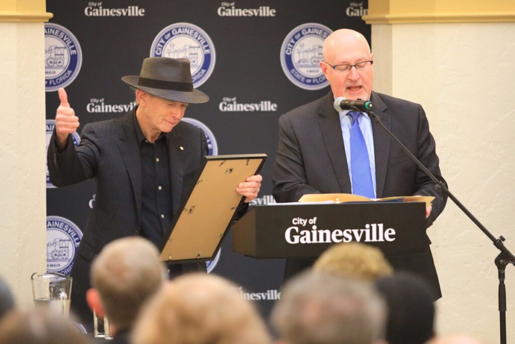 Mayor Harvey Ward reads a city proclamation in honor of Benmont Trench while Trench gives a thumbs up in support. Photo by Seth Johnson