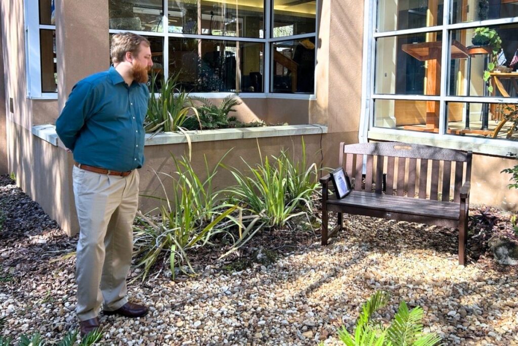 Pastor Kolby Golliher gazes at the bench at Shir Shalom. Photo by Ronnie Lovler