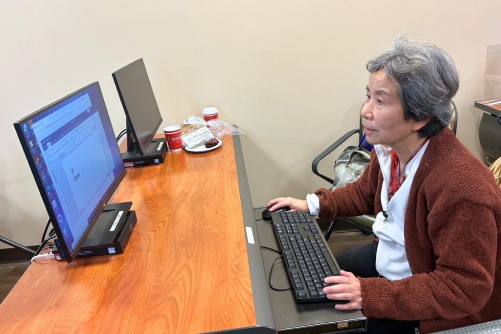 Rong Ran practices on a computer after a class at the senior center in Gainesville. Photo by Ronnie Lovler