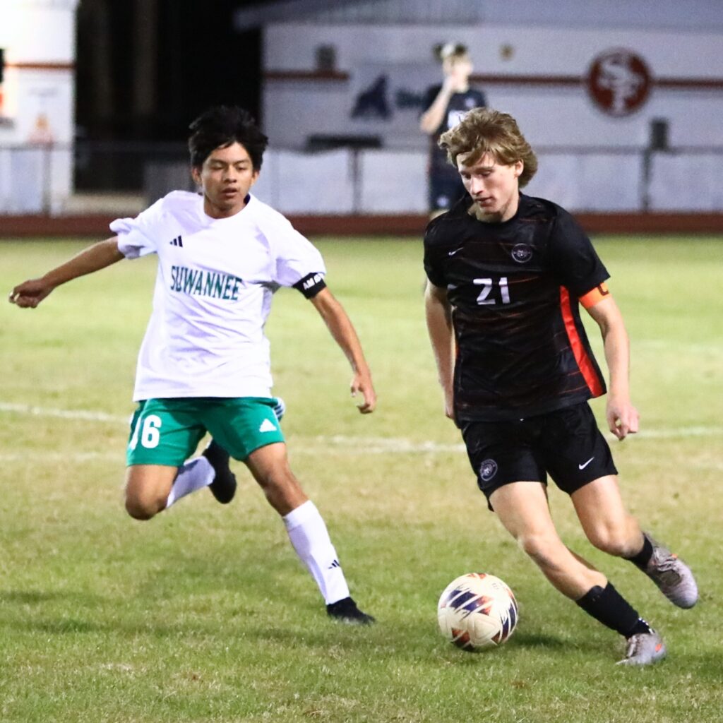 Santa Fe's Mason Kramer (21) dribbles the ball downfield against Suwannee in the Class 3A-Region 1 Quarterfinals. Photo by C.J. Gish