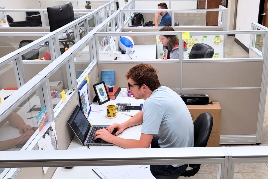 Seth Johnson, Lillian Hamman and Nick Anschultz working in their cubicles at Mainstreet Daily News. Photo by C.J. Gish