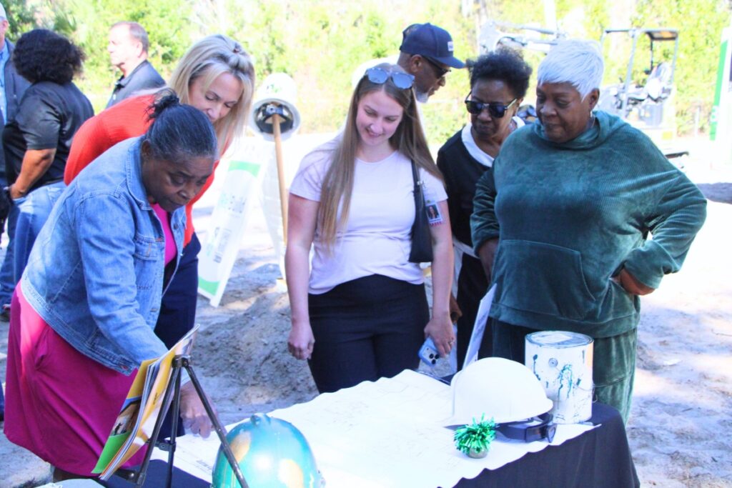 Tlama White (far right) reviews blueprints for her new 858-square-foot home in Chiefland. Photo by Lillian Hamman