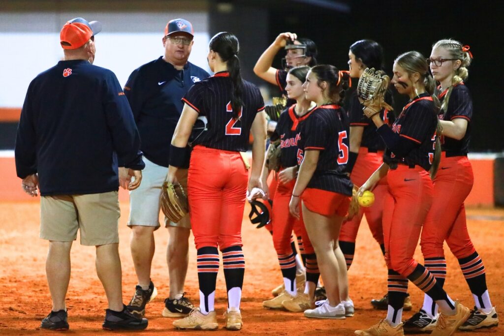 Trenton coach Kevin Benson (wearing glasses) talks things over with his team after the Tigers take a 7-1 lead in the fourth inning against Gainesville. Photo by C.J. Gish