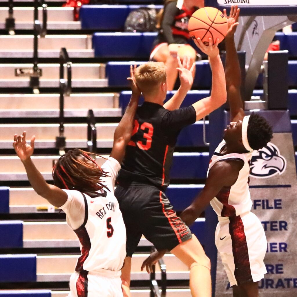 Trenton's Marc Micale (23) attempts a shot against Williston defenders in the Rural state semifinals. Photo by C.J. Gish