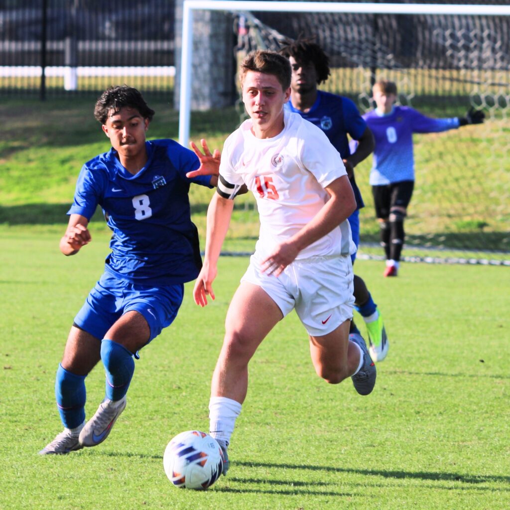 Wayne Boone moves the ball up the pitch with a defender draped on him against Somerset Academy-Canyons (Boynton Beach) in the Class 3A state semifinals. Photo by Vinnie Cammarano