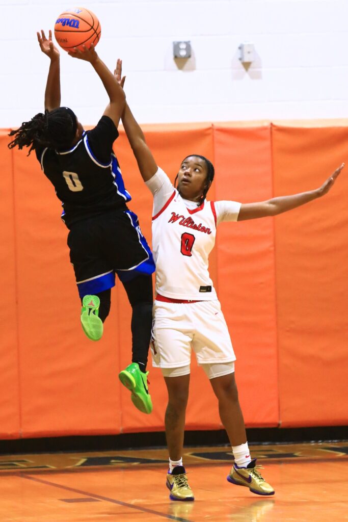 Williston's Ashlyn Young (0) attempts to block a shot against Wildwood in the Rural Class District 7 championship game. Photo by C.J. Gish