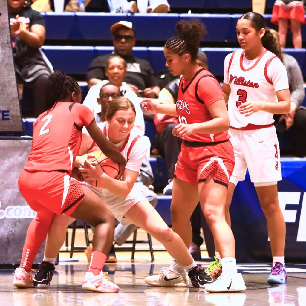 Williston's Baylee Cribbs (12) ties up the ball against Blountstown in the Rural state semifinals. Photo by C.J. Gish