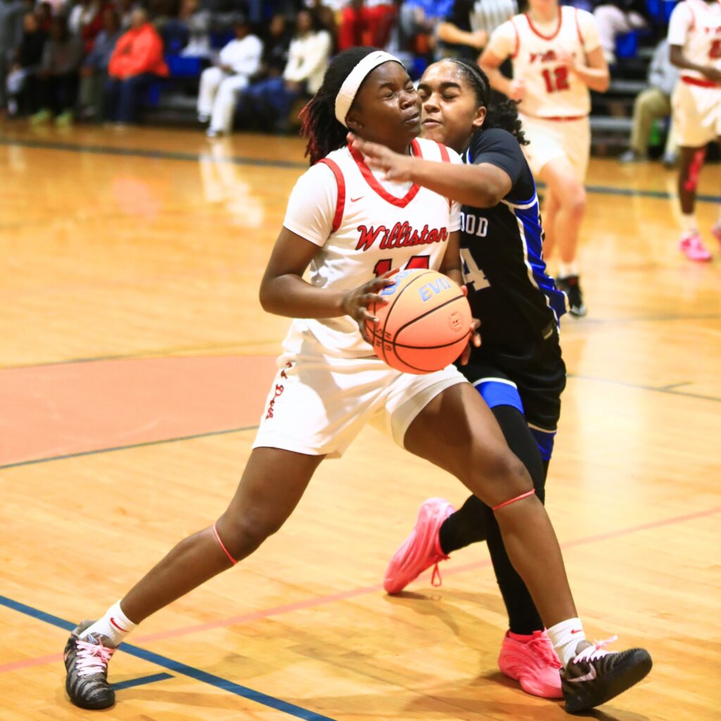 Williston's Janiyah Span (14) gets fouled driving to the basket against Wildwood in the Rural Class District 7 championship game. Photo by C.J. Gish