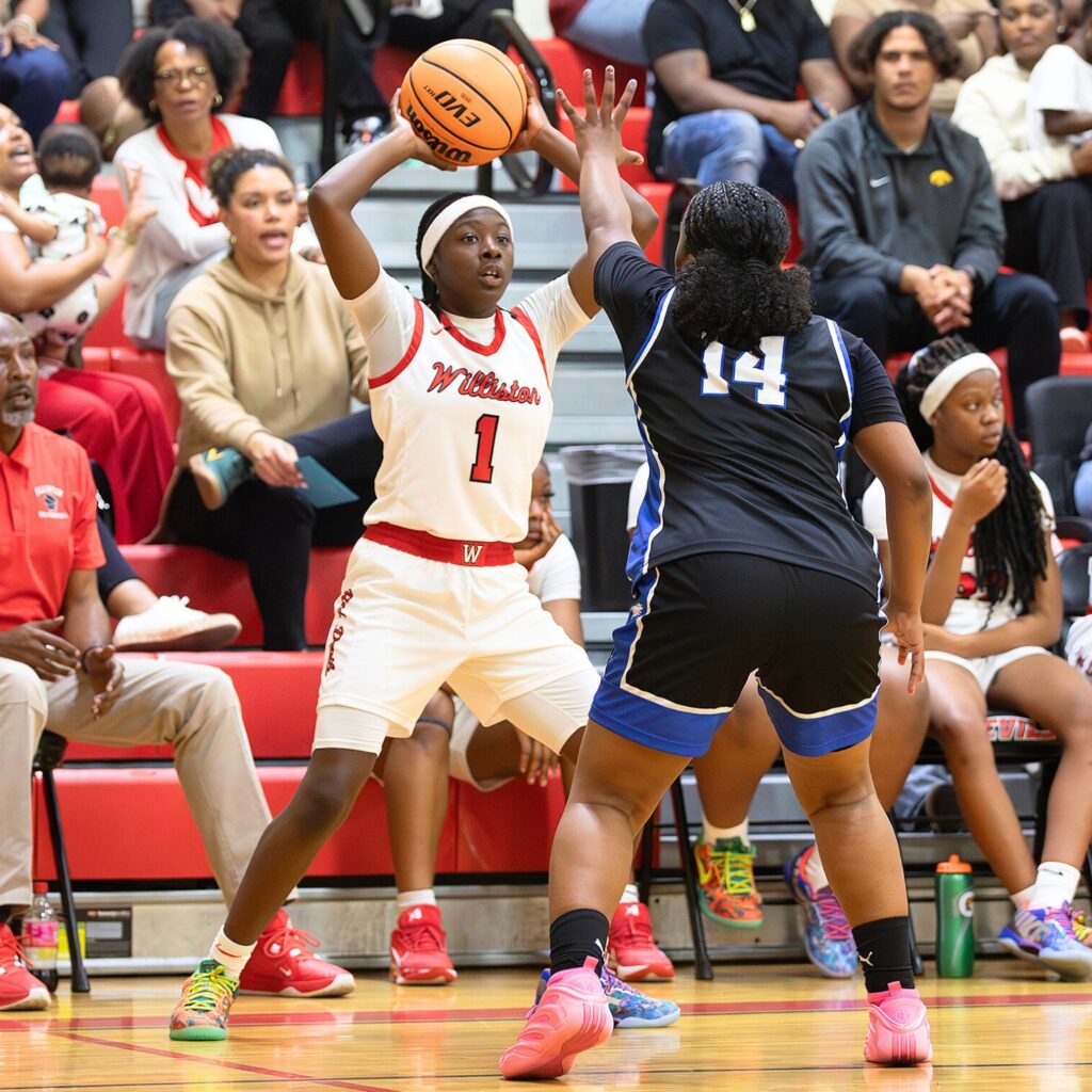 Williston's Kierce Solomon (1) prepares to lob the ball across court against Wildwood in the Rural-Region 4 Final. Photo by Megan V. Winslow