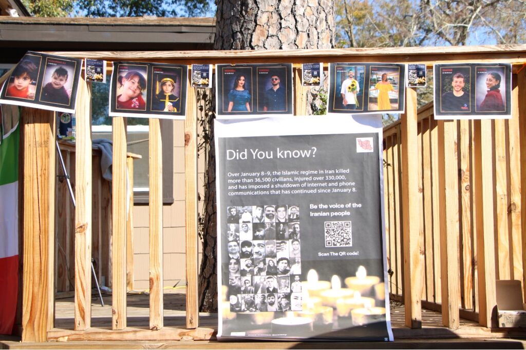 Ziba Ahmadi, whose sister was killed in Iran in 2020, dons the porch of her Ziba De Beaute salon with a memorial for Iranians killed by an Islamic regime. Photo by Lillian Hamman