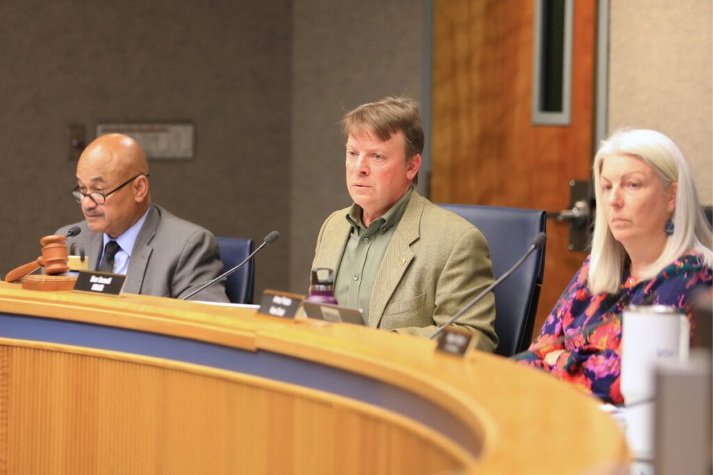 County commissioners sit behind the dais.