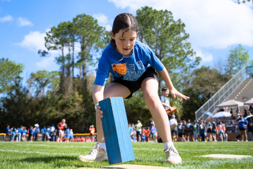 Briar Nappy placing a block in the block race for Fifth Grade Field Day at Citizens Field. Photo by Tim Rodriquez